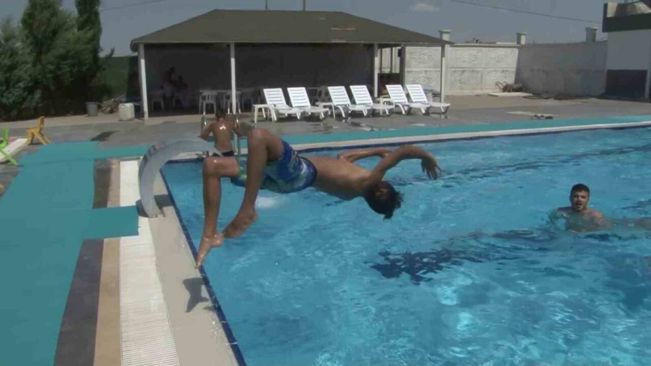 Hava sıcaklığının etkili Adıyaman’da gençler çareyi havuzlarda yüzerek serinlemekte buluyor.