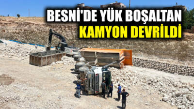 Besni'de yük boşaltma sırasında kontrolden çıkan kamyon devrildi.