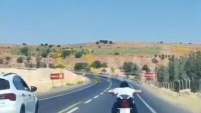 Şanlıurfa’da trafikte güvenliği tehlikeye atacak şekilde motosiklet koltuğuna yüzüstü uzanarak