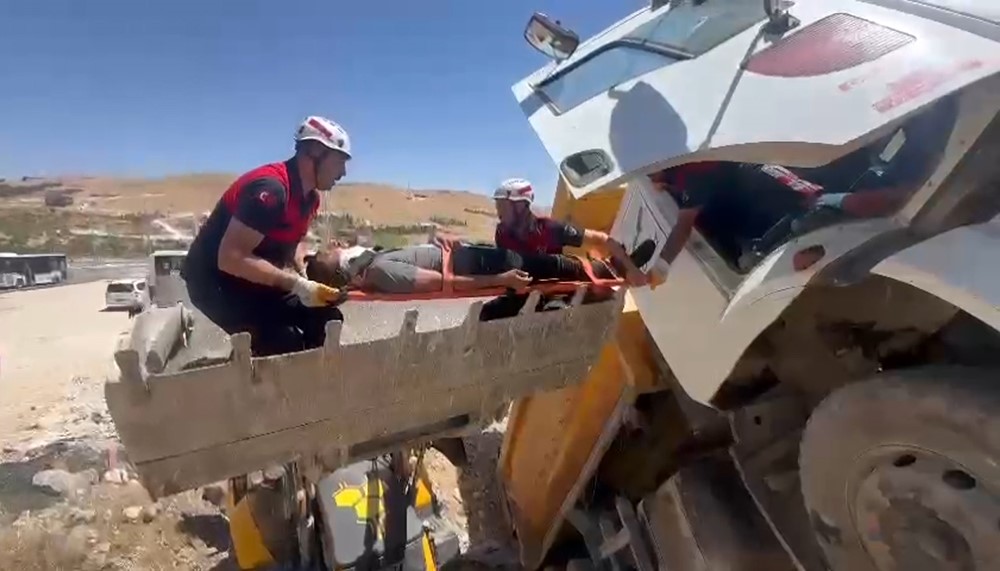 Şanlıurfa’da kontrolden çıkarak şarampole devrilen kamyonun sürücüsü itfaiye tarafından kepçenin