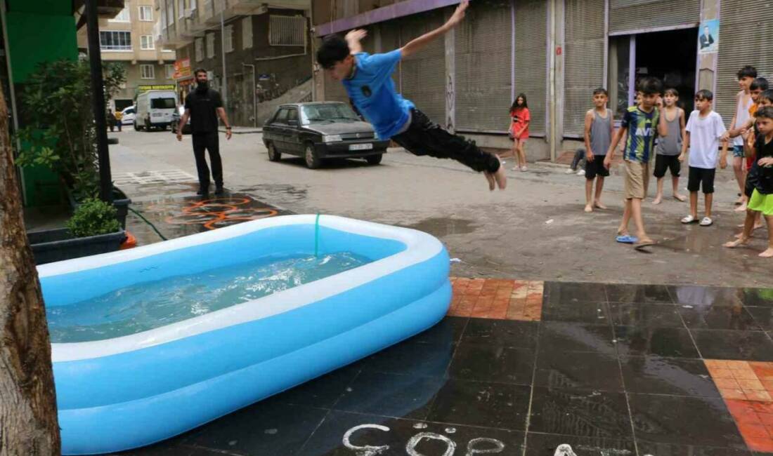 Hava sıcaklıklarının 45 derecenin üzerinde seyrettiği Diyarbakır’da bir esnaf, çocuklara