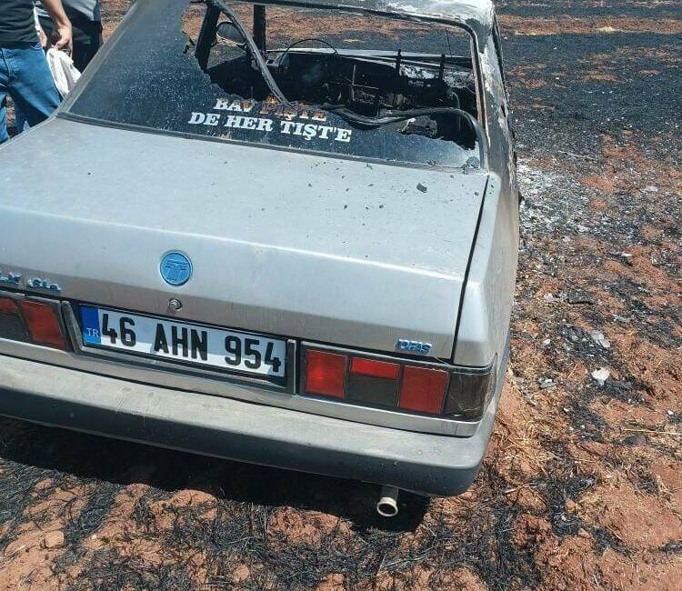 Siverek ilçesinde çıkan tarla yangınında bir vatandaşın otomobili alevler arasında