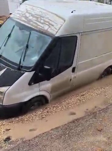 Minibüs çöken yolda mahsur kaldı Adıyaman’da yoğun yağışların ardından yolda oluşan çukura saplanan bir minibüs