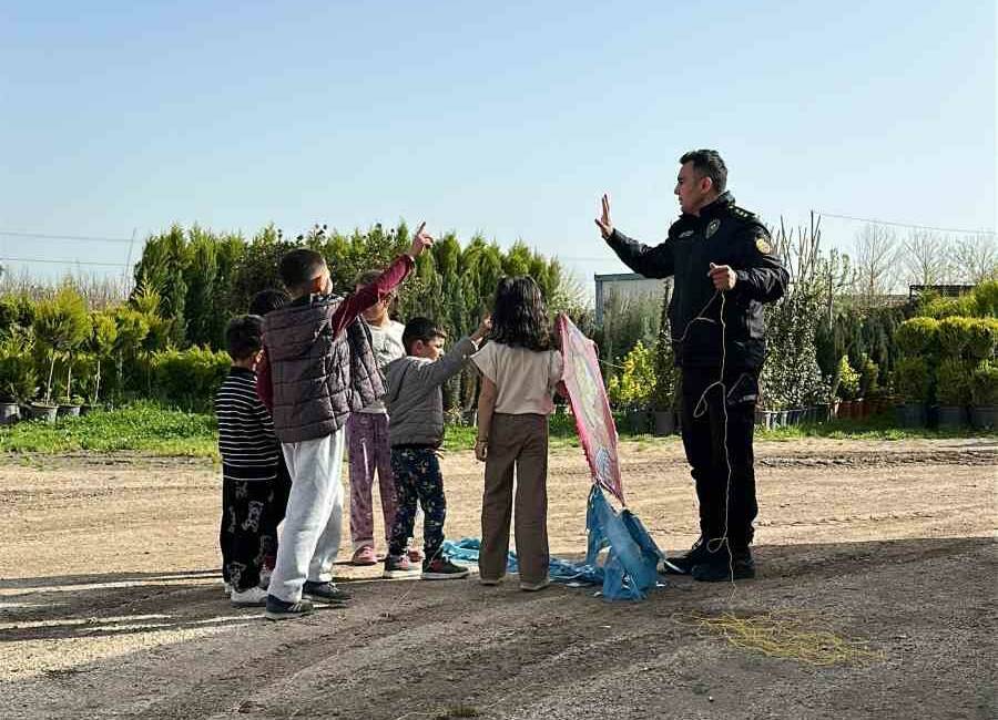 Mardin'de yağışların durmasıyla sokaklara çıkan çocuklar uçurtma uçururken, bir polis