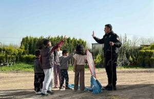 Mardin'de yağışların durmasıyla sokaklara çıkan çocuklar uçurtma uçururken, bir polis