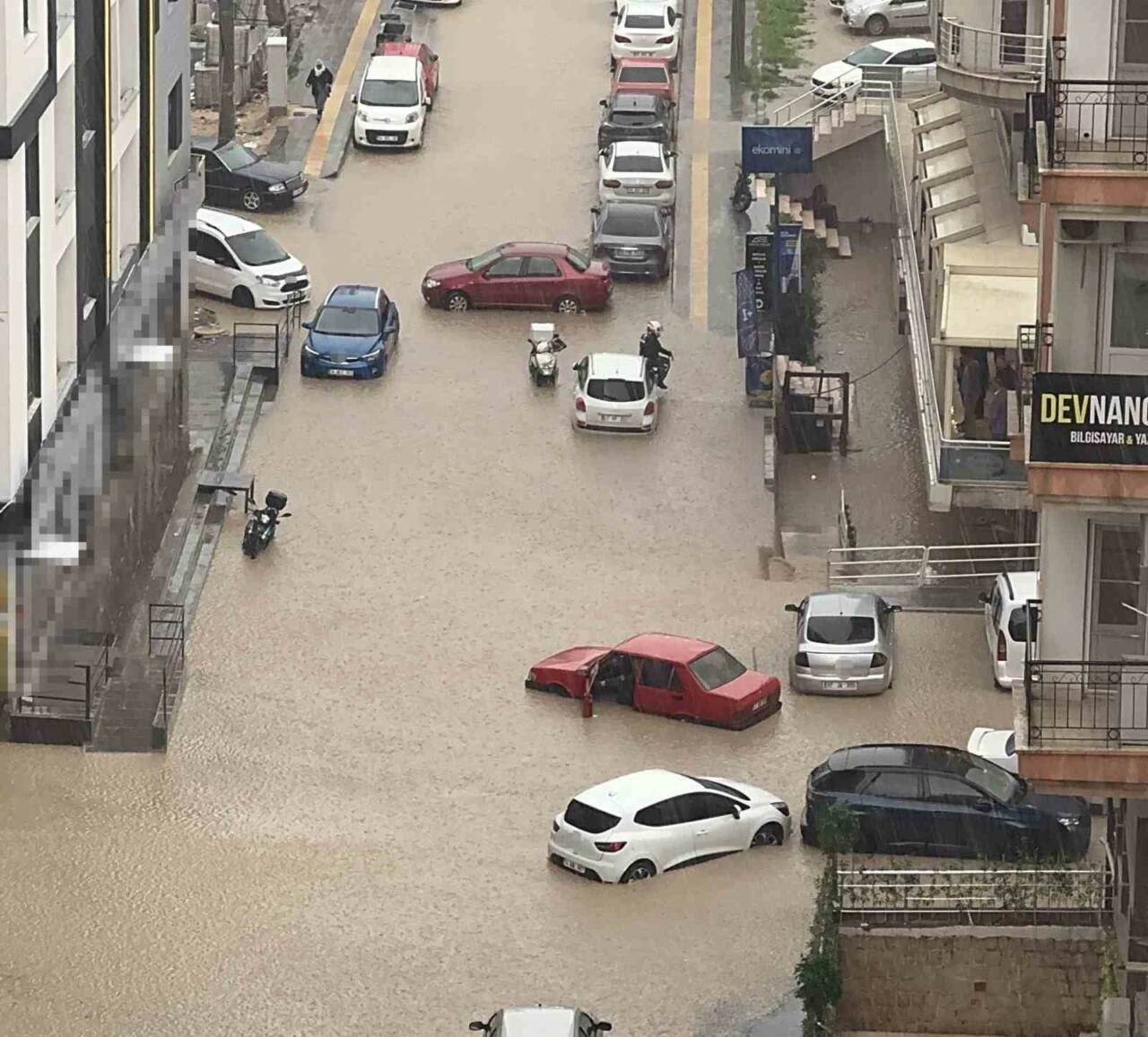 Mardin’in Artuklu ilçesinde etkili olan sağanakla birlikte mahsur kalan motosiklet